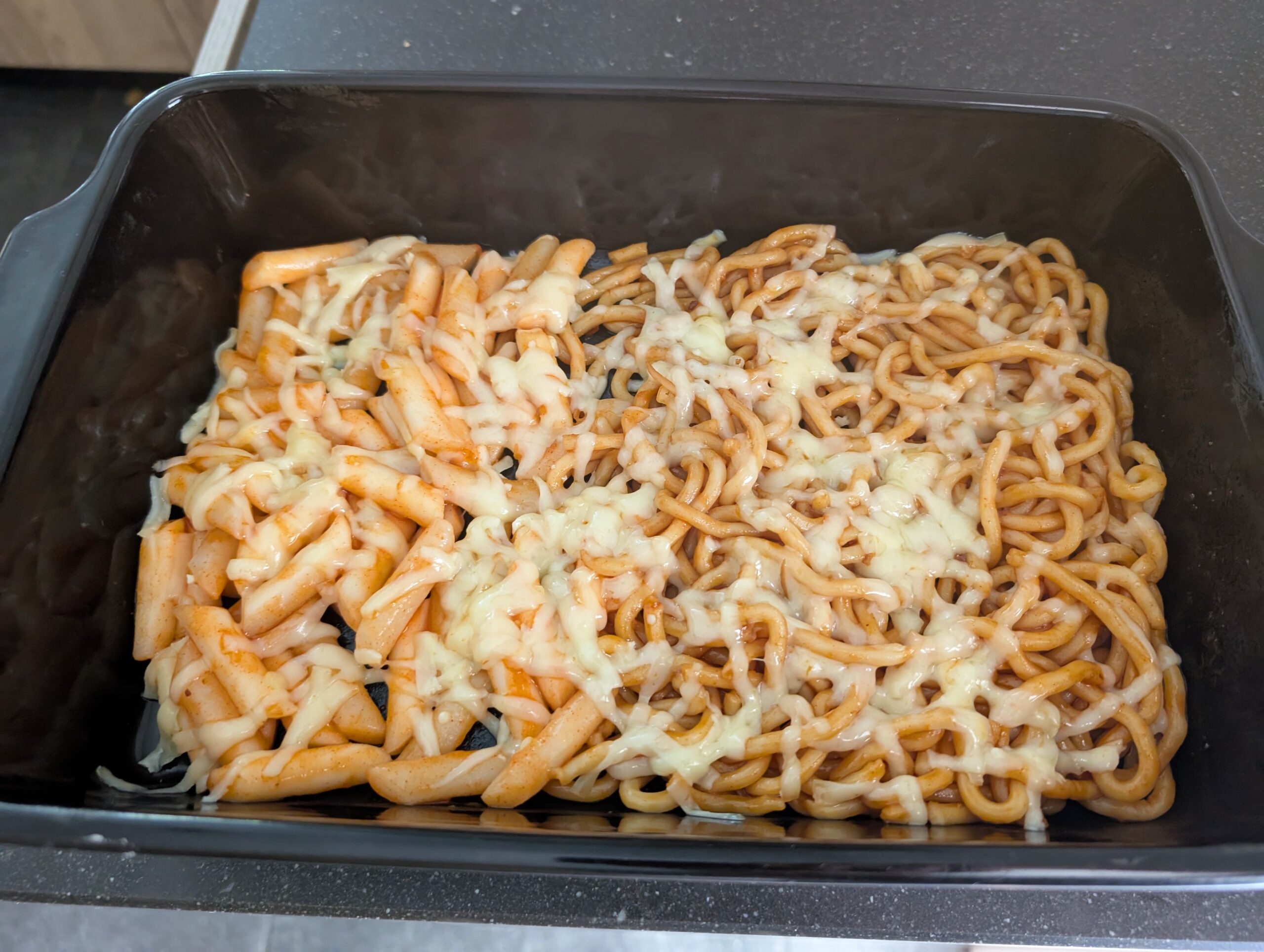 Udon noodles met gesmolten kaas in kom