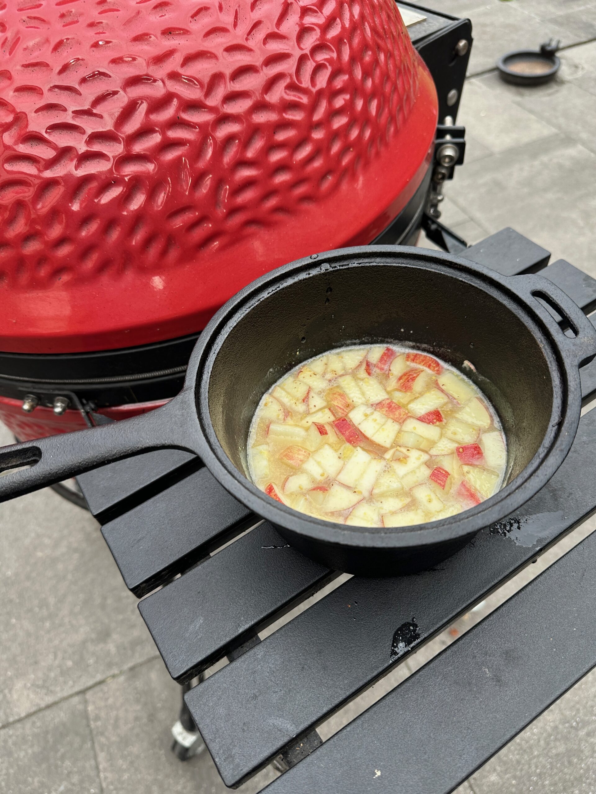 Zelfgemaakte cider-mosterdsaus in pannetje naast kamado grill