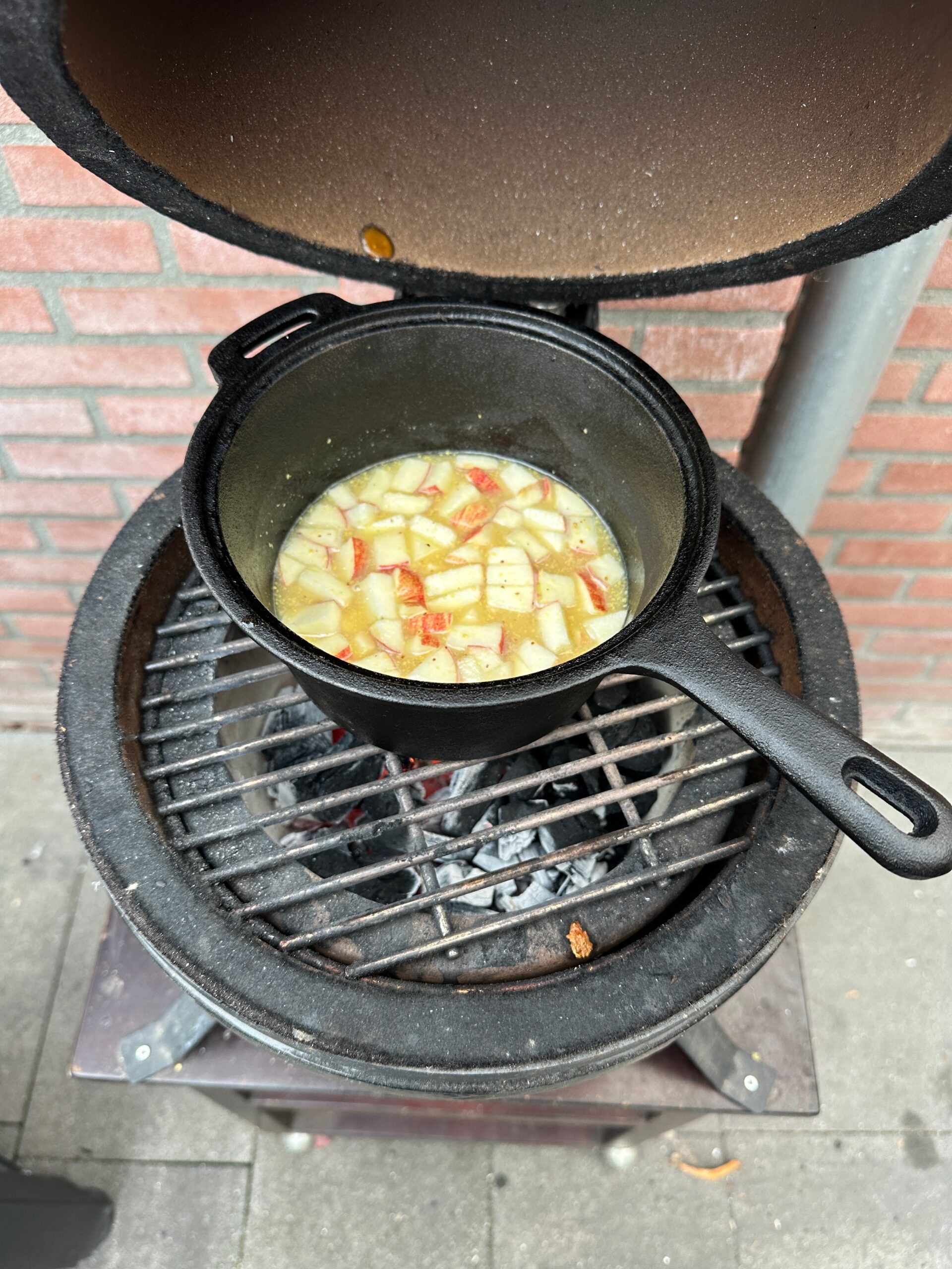 Zelfgemaakte cider-mosterdsaus in pannetje naast kamado grill