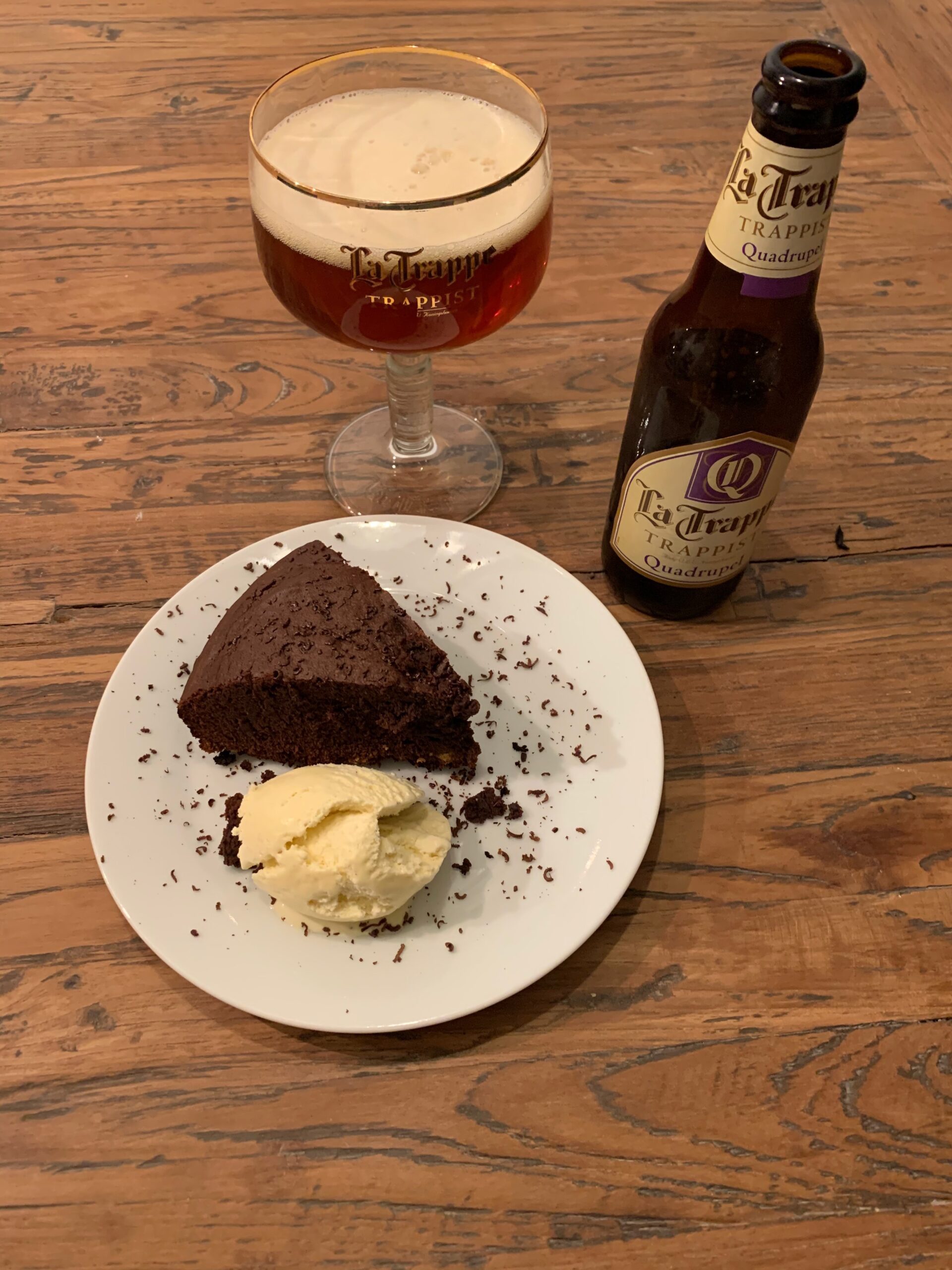 Warme chocolate brownie in gietijzeren Dutch oven met vanille-ijs op BBQ tafel