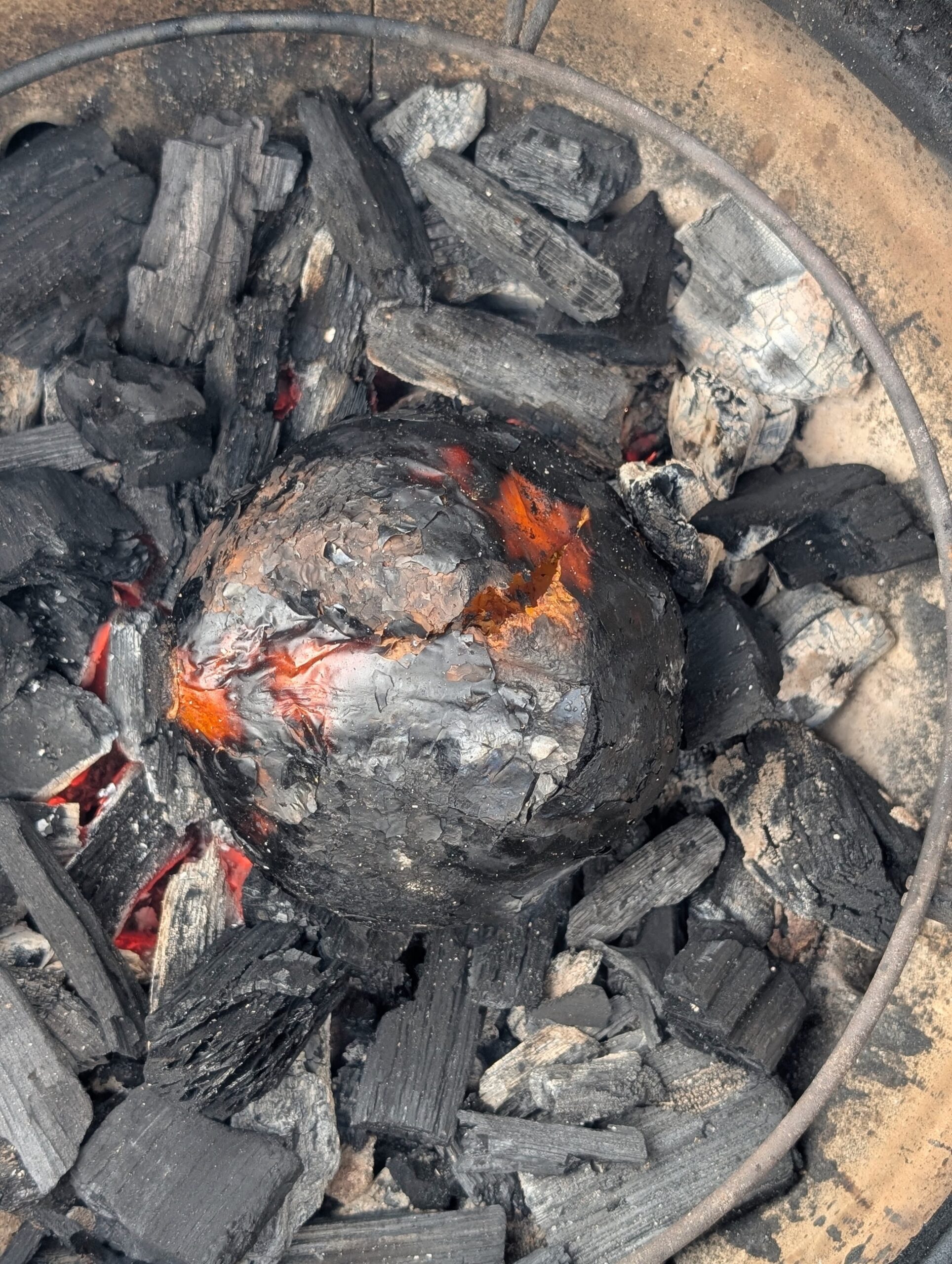Gegrilde pompoen direct tussen BBQ kolen caveman-stijl