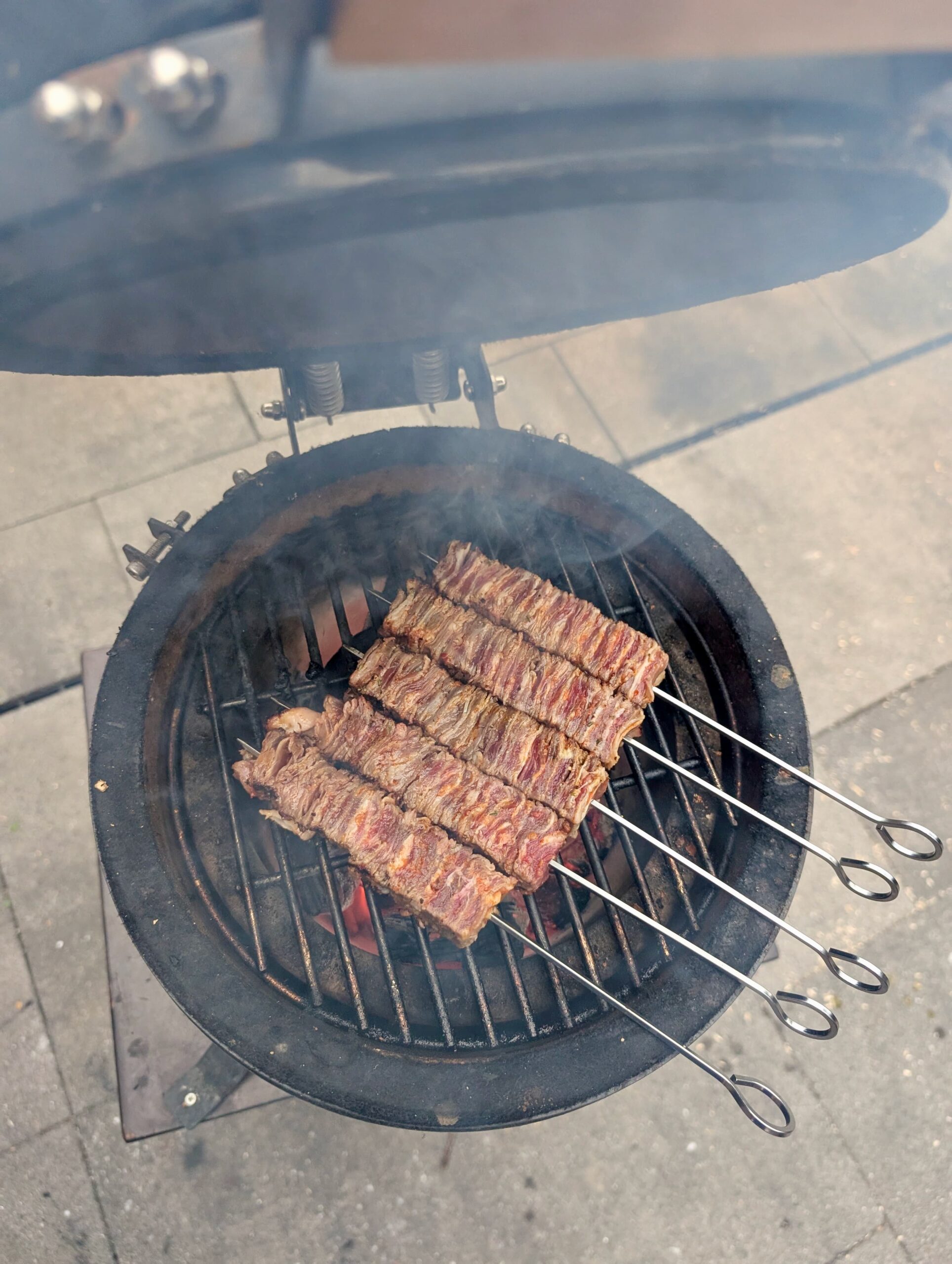 Vierkante vleesspies op rvs barbecue rooster