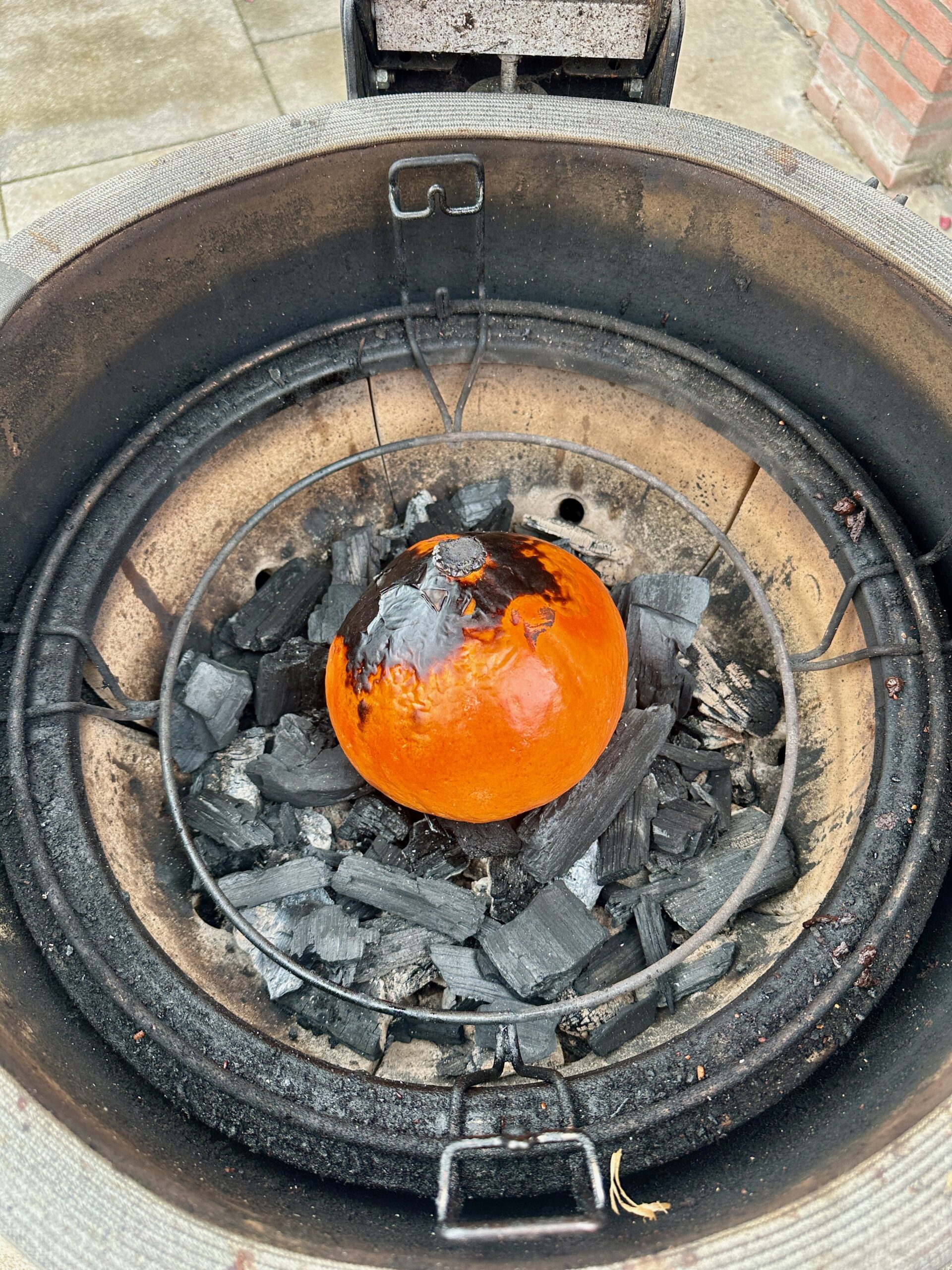 Gegrilde pompoen direct tussen BBQ kolen caveman-stijl