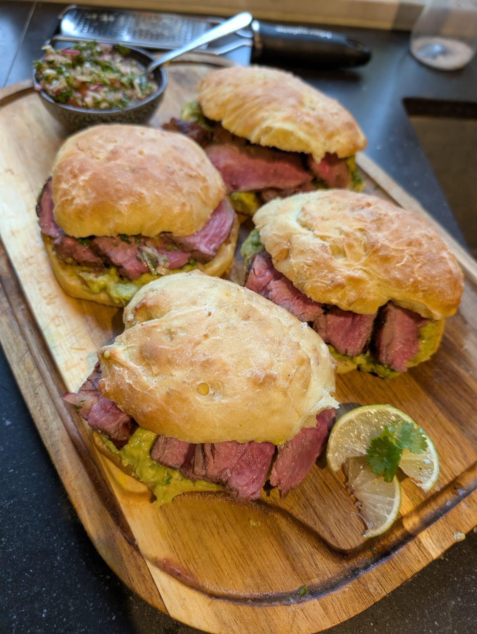 Gegrilde steak op zelfgemaakt maisbroodje met guacamole en ingelegde rode ui