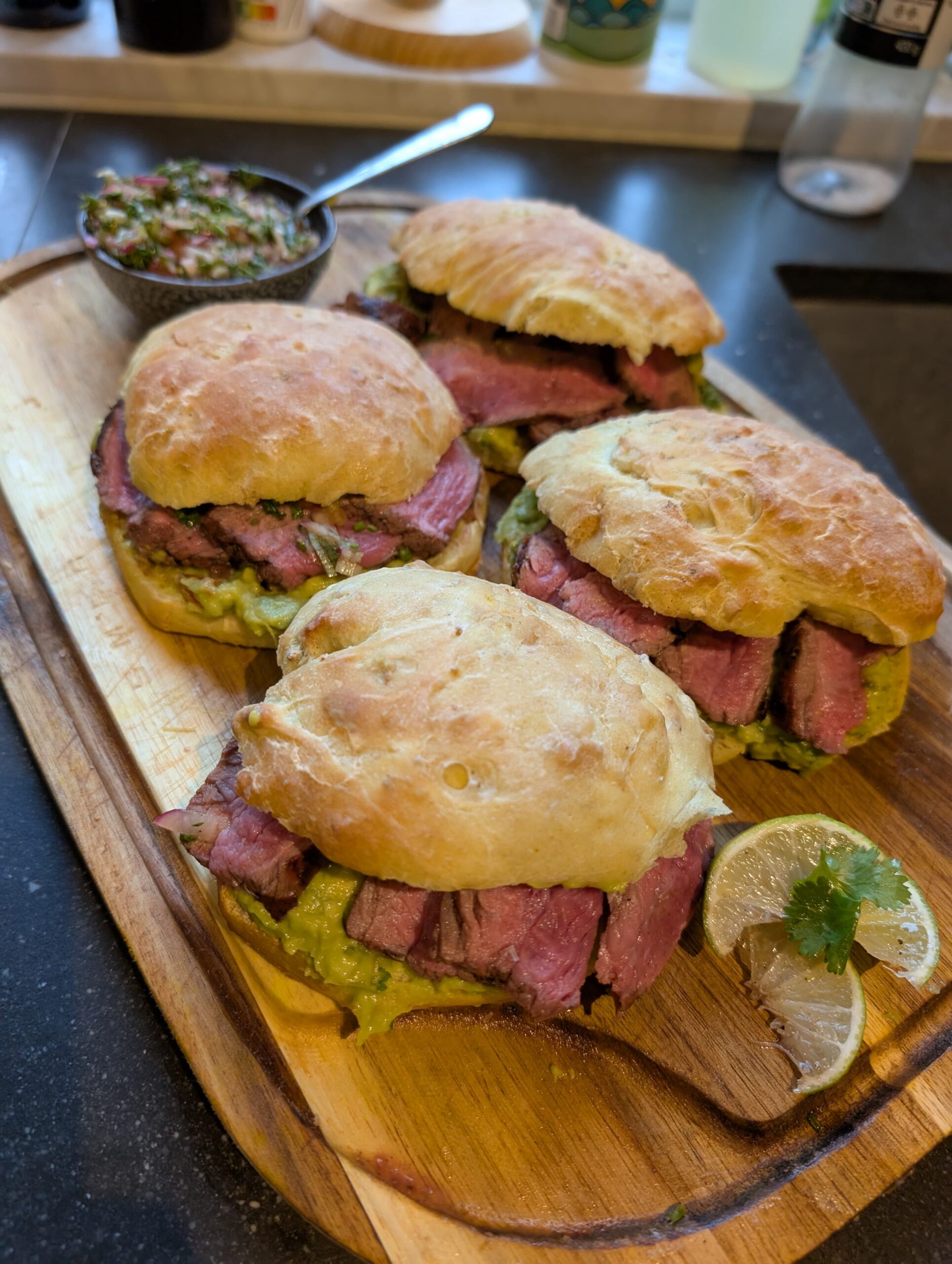 Gegrilde steak op zelfgemaakt maisbroodje met guacamole en ingelegde rode ui